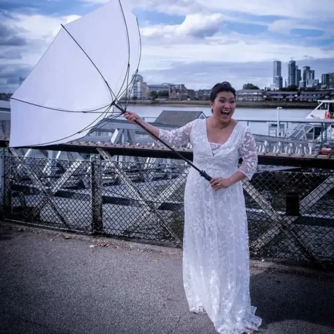 bride holding an umbrella that had been blown inside out